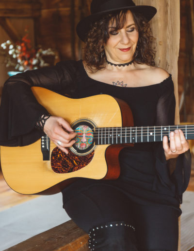 Lisa on railing playing guitar